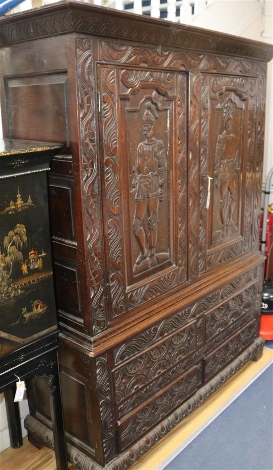 A large carved oak cupboard W.140cm
